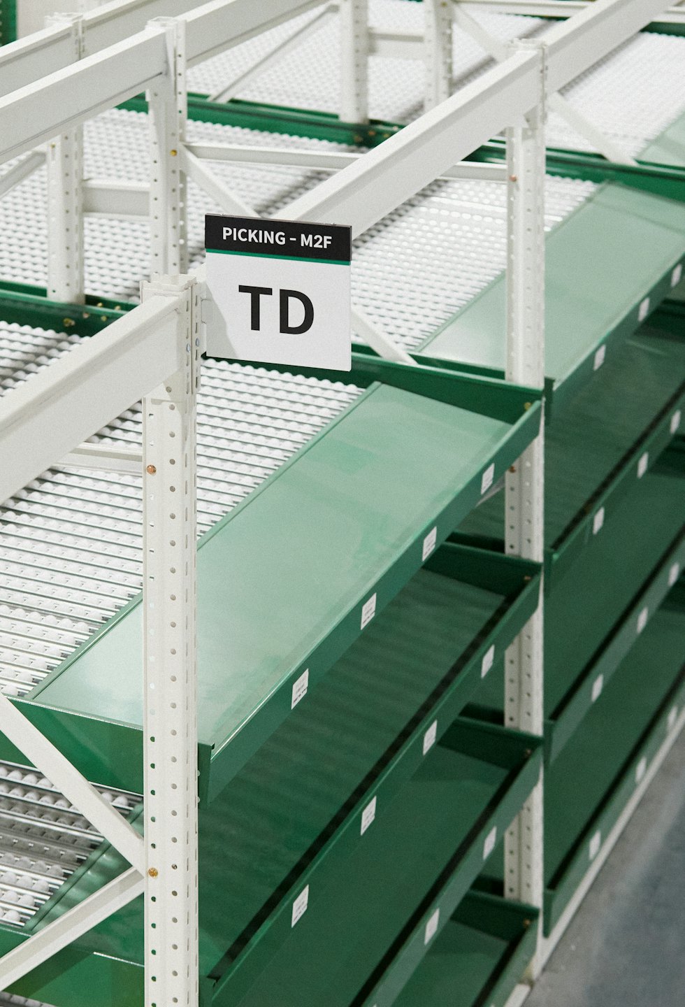 Rijen georganiseerde industriële stellingen met groene flowracks.